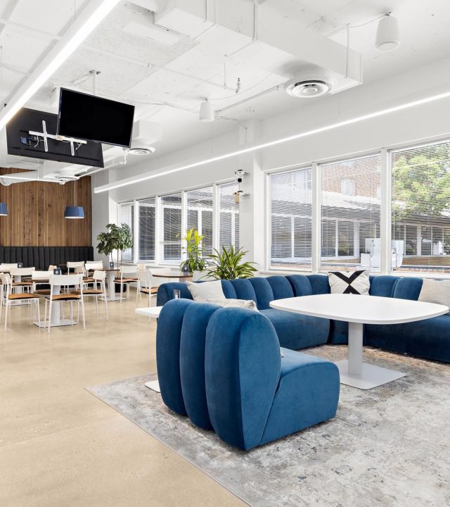 Blue lounge seating and shared tables at Groove Workspace and Studio.